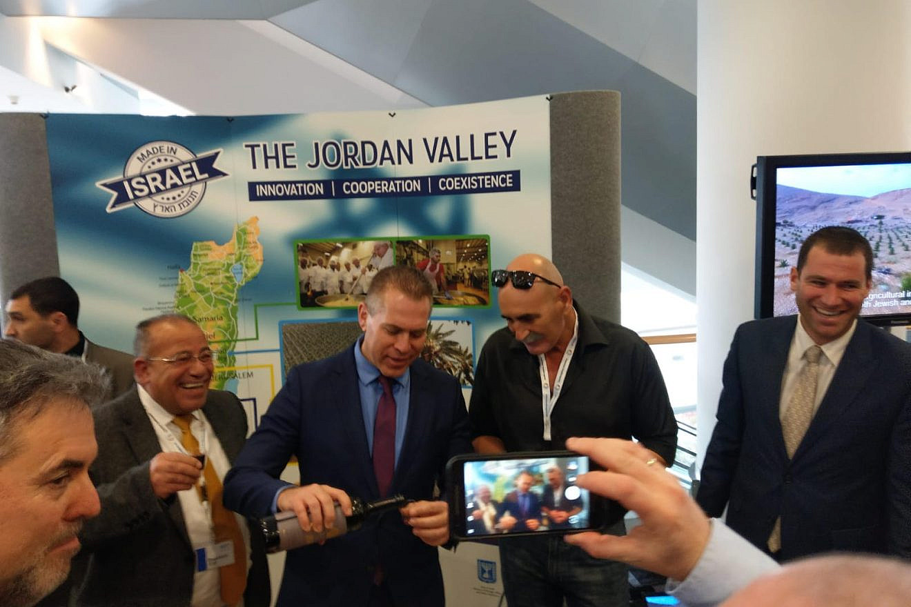 Minister of Strategic Affairs pours wine from Judea and Samaria at Israel Kongress in Frankfurt, together with the head of the Jordan Valley Regional Council David Elhayani and Palestinian human-rights activist Baseem Eid. Credit: Jordan Valley Regional Council.