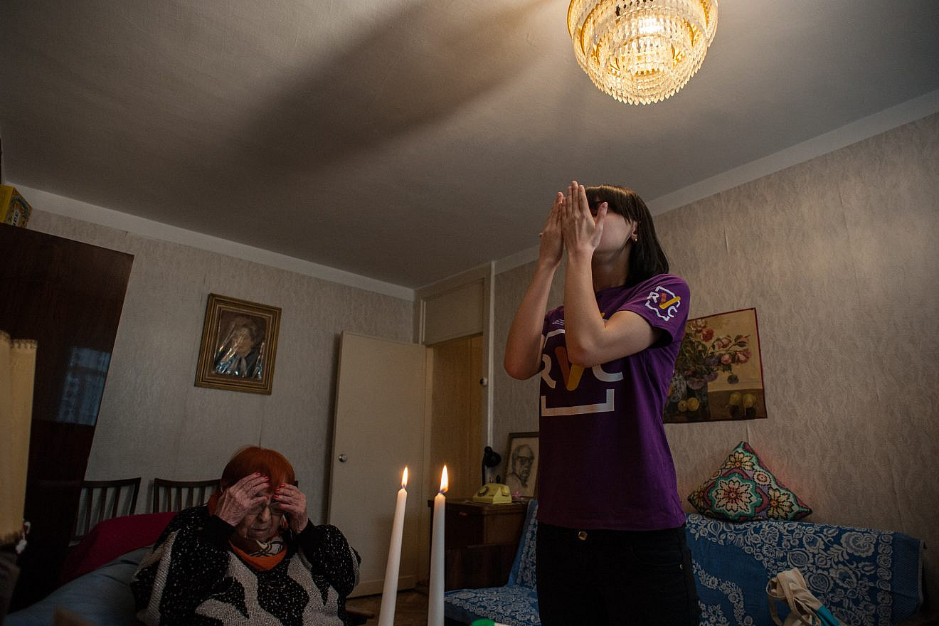 A young Jewish volunteer in Chisinau, Moldova, celebrates Shabbat traditions with Ira G, a homebound senior suffering medical issues who lives on roughly $3.5 dollars a day. Credit: Arik Shraga for JDC.