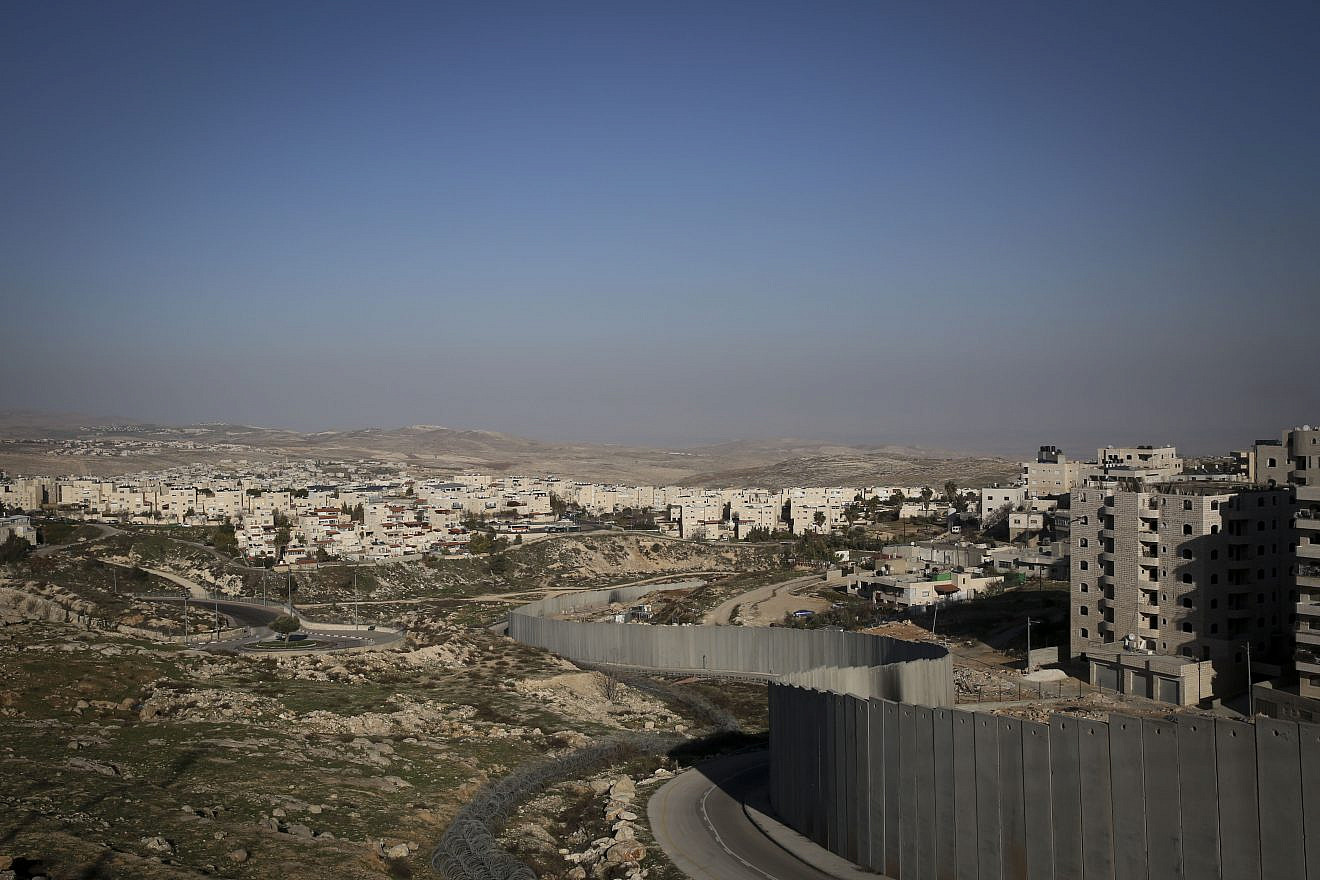 The separation wall runs along the Palestinian refugee camp, Shuafat, separating it from the Jewish town of Pisgat Ze'ev, near Jerusalem, on Jan. 29, 2014. Photo by Hadas Parush/Flash 90.