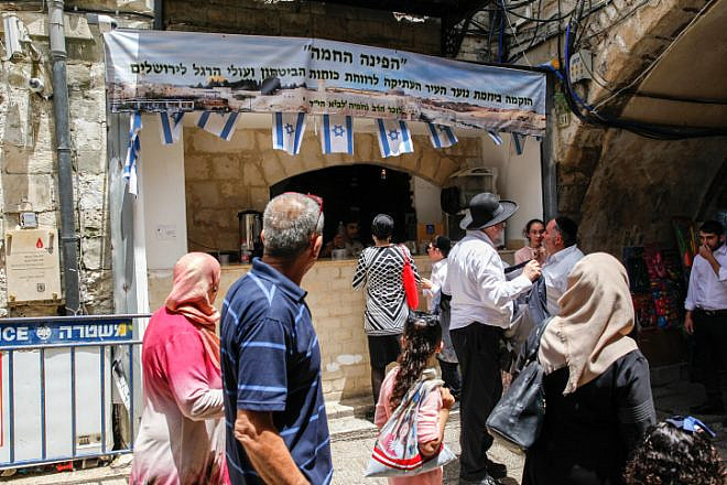 Muslims walk near a shop belongs to Israelis during Ramadan in the Muslim Quarter of Jerusalem's Old City on May 20, 2018. Photo by Sliman Khader/Flash90.