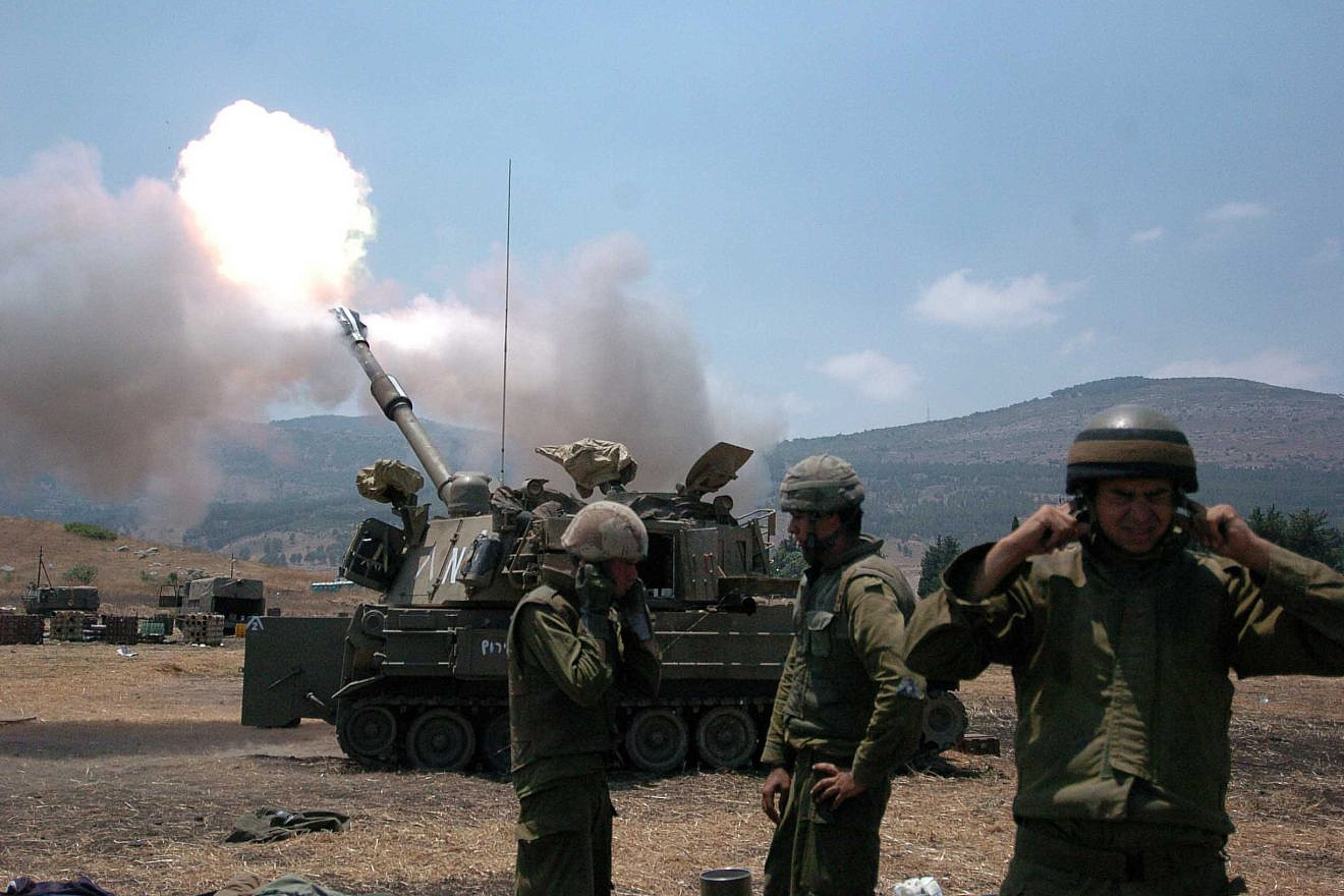 Israeli soldiers cover their ears as a tank fires into Lebanon from Kiryat Shemona on July 20, 2006, during the Second Lebanon War. Credit: Guy Assayag /Flash90.