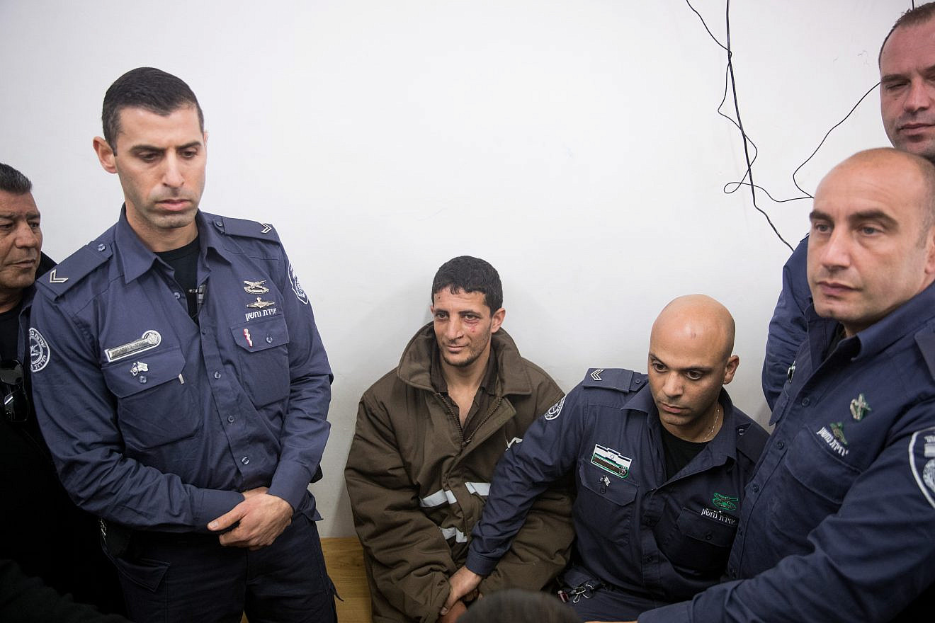 Police escort a Palestinian charged with the murder of 19-year-old Ori Ansbacher, at the Jerusalem Magistrate's court, on Feb. 11, 2019. The suspect was captured hiding in Ramallah after Israeli forces investigated the scene where the young woman was found dead last week in Ein Yael, in the outskirts of Jerusalem. Photo Yonatan Sindel/Flash90.