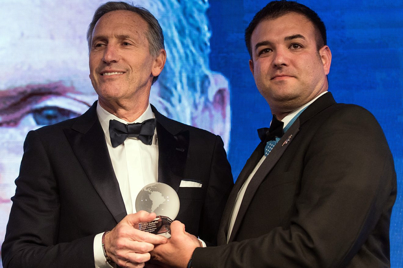 Retired U.S. Army Master Sgt. Leroy A. Petry presents Howard Schultz (left), executive chairman of Starbucks Corporation, with the Distinguished Business Leadership Award at the Atlantic Council’s Distinguished Leadership Awards dinner in Washington, D.C., on May 10, 2018. Credit: DoD Photo by U.S. Army Sgt. James K. McCann.