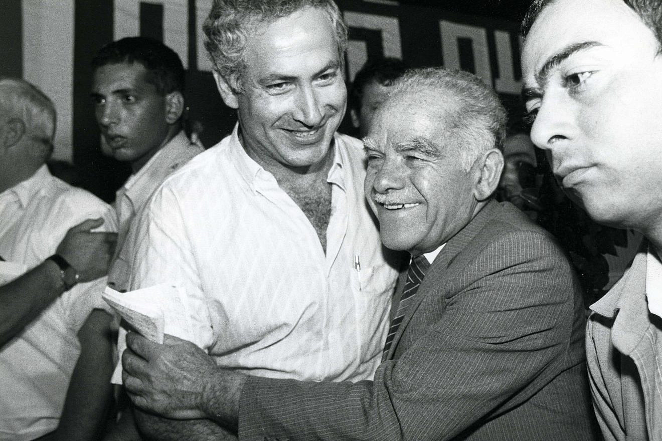 Former Prime Minister Yitzhak Shamir (right) laughs with current Prime Minister Benjamin Netanyahu at a Likud Party meeting in 1986. Photo by Moshe Shai/Flash90.