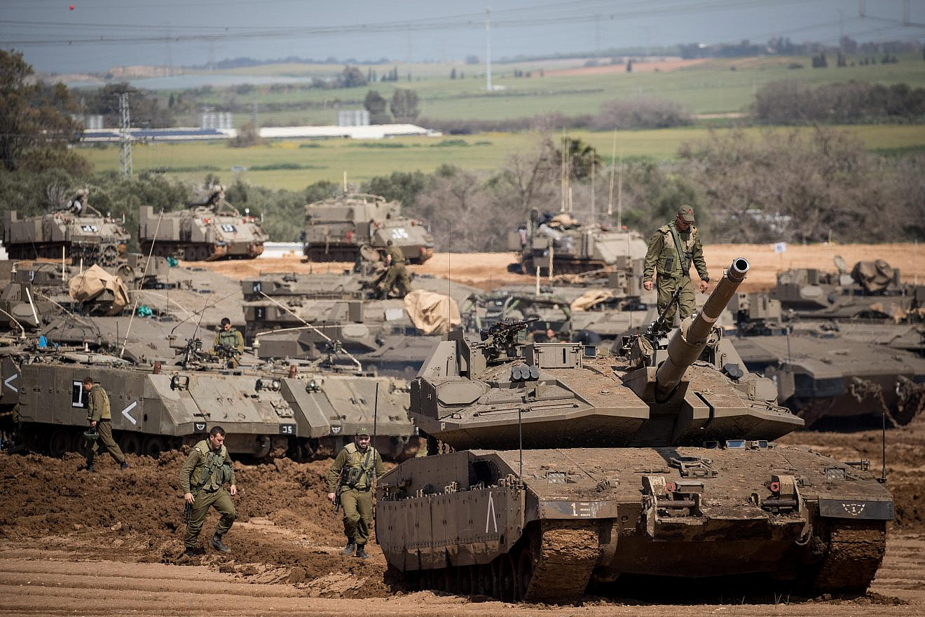 Israeli soldiers seen near IDF tanks stationed near the Israeli Gaza border on March 26, 2019. Credit: Yonatan Sindel/Flash90