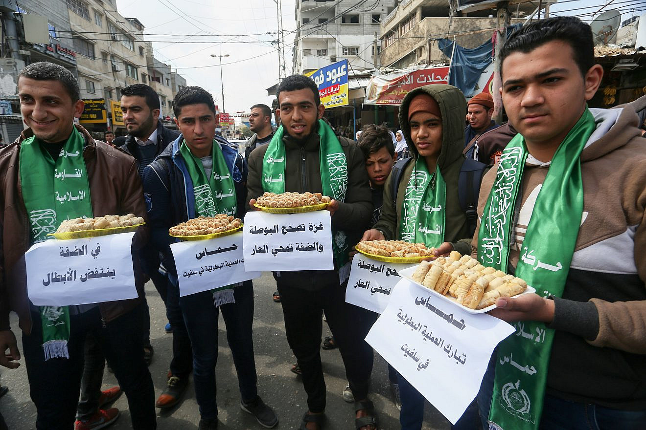 Palestinian supporters of Hamas pass out sweets in Rafah in the southern Gaza Strip on March 17, 2019, after a terrorist attack in which a Palestinian man killed a 19-year-old Israel Defense Forces soldier, stole his weapon and used it to shoot two others near Ariel, in the West Bank. Photo by Abed Rahim Khatib/Flash90.