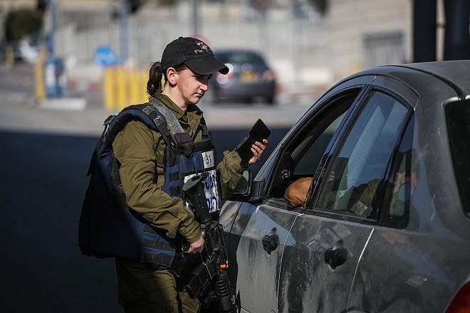 An Israeli soldier from the Erez Battalion in the Military Police checks IDs and Palestinian vehicles at the checkpoint to the Shuafat Refugee Camp in eastern Jerusalem on Dec. 22, 2015. Credit: Hadas Parush/Flash90.