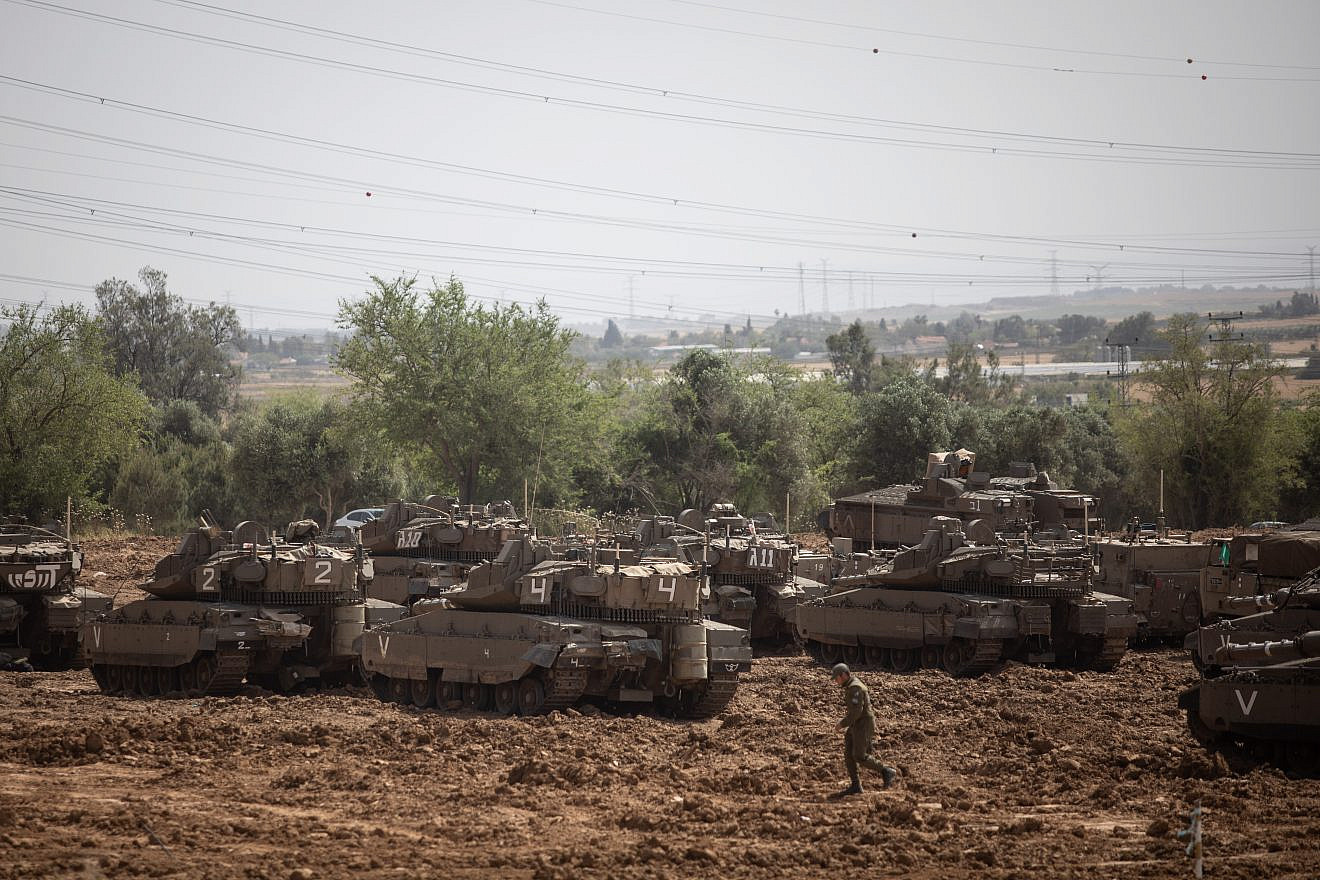 Israeli soldiers seen near IDF tanks stationed near the Israeli Gaza border on May 6, 2019. Credit: Aharon Krohn/Flash90