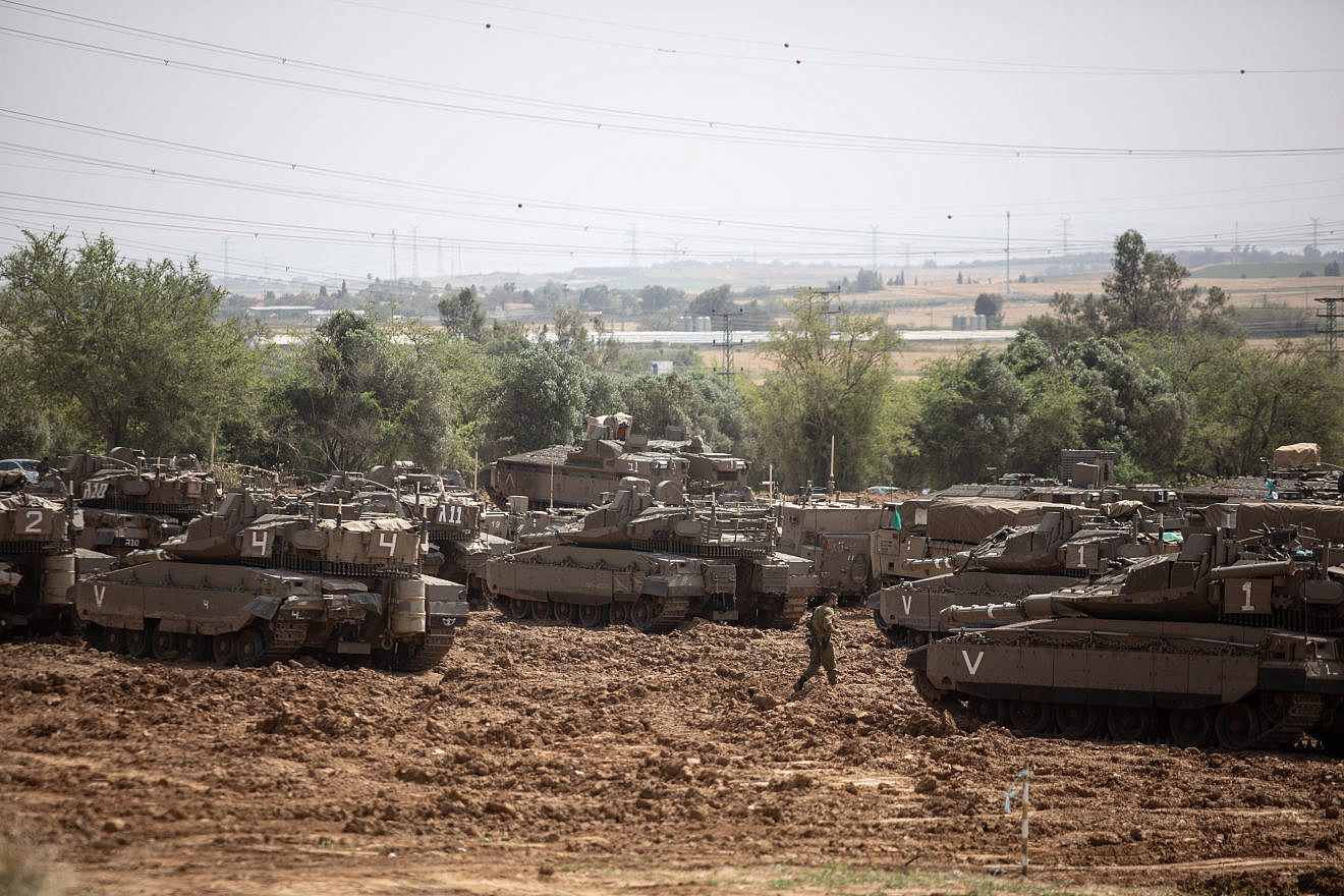Israeli soldiers seen near IDF tanks stationed near the Israeli border with Gaza on May 6, 2019. Credit: Aharon Krohn/Flash90.