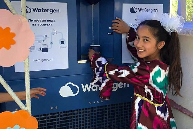 A girl in Bukhara, Uzbekistan, samples water from an atmospheric water generator known as the “GEN-350,” May 2019. Credit: Watergen.