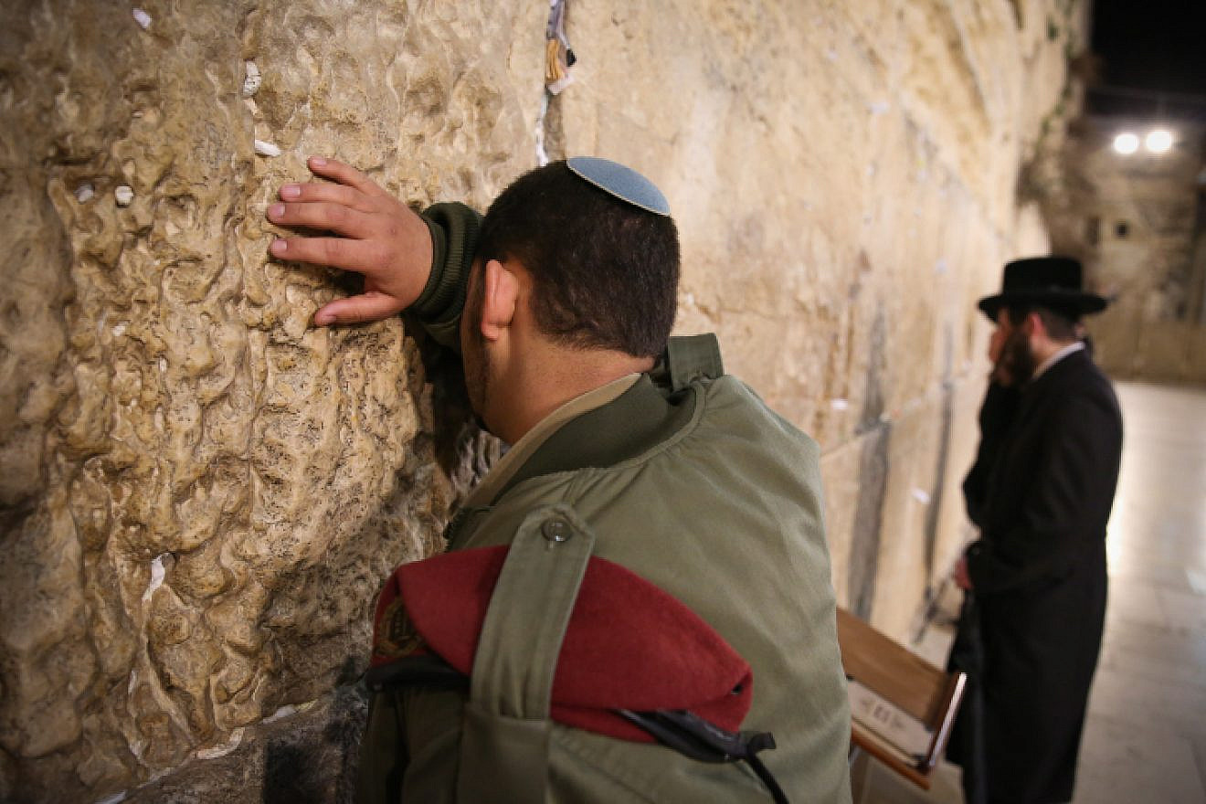 An Israeli soldier and ultra-Orthodox Jewish man pray at the Western Wall, Judaism's holiest site, in Jerusalem's Old City, March 14, 2019. Photo by David Cohen/Flash90.