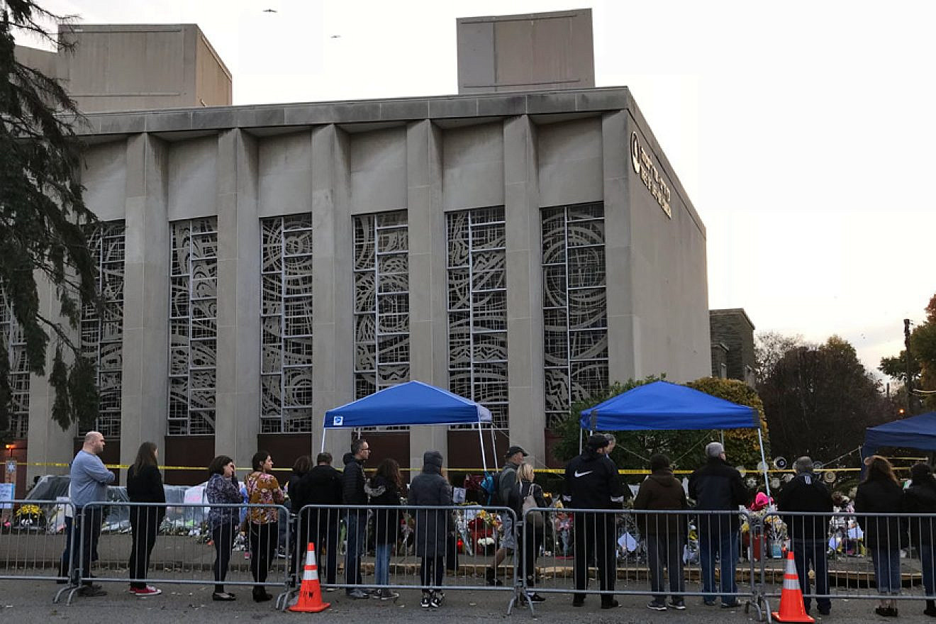 People pay their respects at a memorial in front of the Tree of Life Synagogue in the Squirrel Hill neighborhood of Pittsburgh to the 11 Jewish victims of a mass shooting a week earlier, Nov. 4, 2018. Credit: Wikimedia Commons.