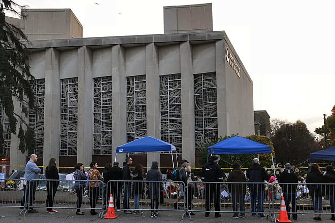 People pay their respects at a memorial in front of the Tree of Life Synagogue in the Squirrel Hill neighborhood of Pittsburgh to the 11 Jewish victims of a mass shooting a week earlier, Nov. 4, 2018. Credit: Wikimedia Commons.