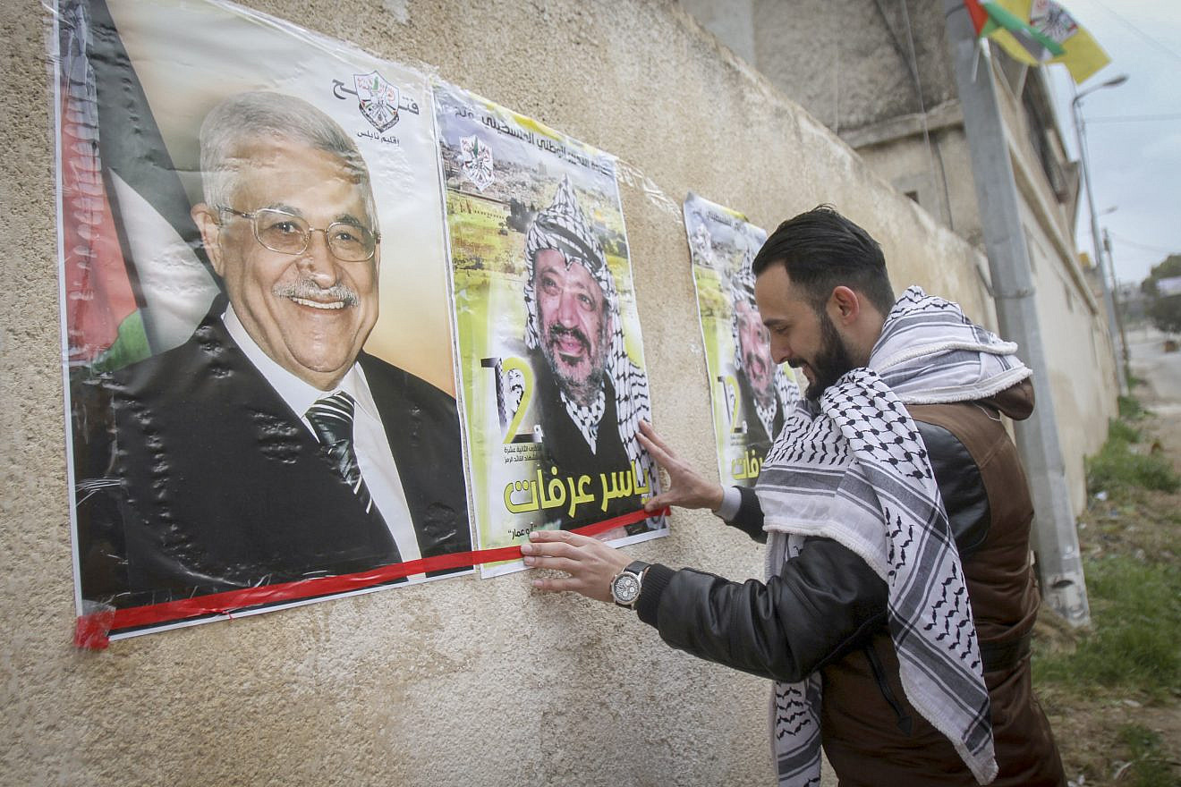 Palestinians hang posters depicting the late Palestinian chief Yasser Arafat and the current Palestinian leader Mahmoud Abbas in the West Bank city of Nablus, March 14, 2017. Photo by Nasser Ishtayeh/Flash90.