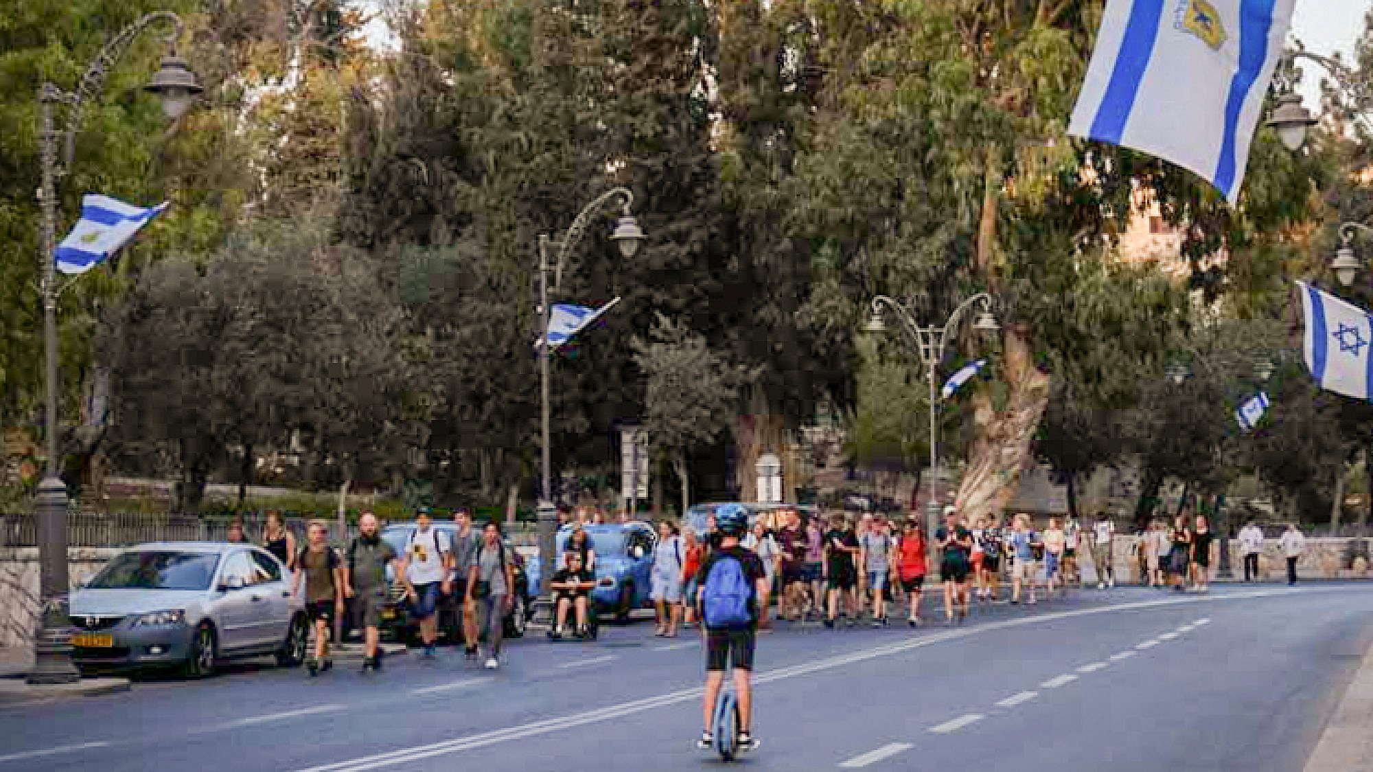 People walk along an empty road in Jerusalem on Yom Kippur, Oct. 9, 2019. Credit: Sara Klatt/Flash90.