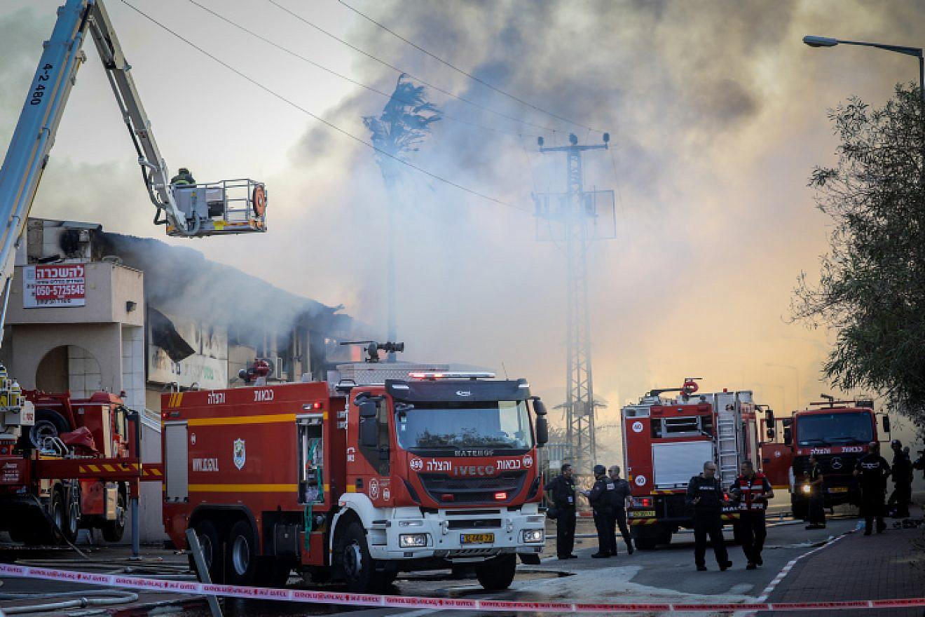 Israeli firefighters work to extinguish a fire at a factory in the town of Sderot caused by a rocket fired from the Gaza Strip, Nov. 12, 2019. Photo by Noam Revkin Fenton/Flash90.