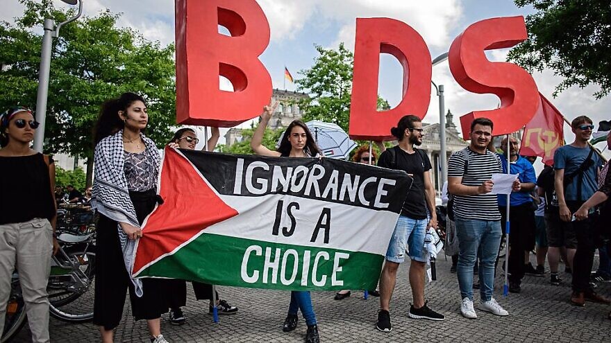 Protesters in Berlin hold a Palestinian flag and the initials of the anti-Israel BDS movement while Israeli Prime Minister Benjamin Netanyahu was visiting Germany in August 2019. Credit: Israel Hayom.