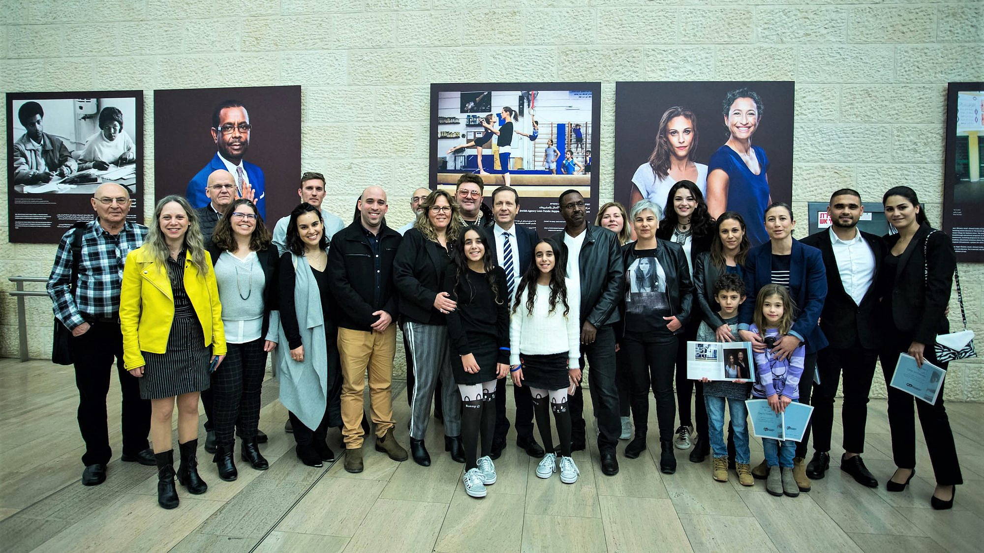 Jewish Agency for Israel chairman Isaac Herzog and CEO Amira Ahronoviz (at center) with some of the subjects of the exhibit. Photo by Dror Sithakol.