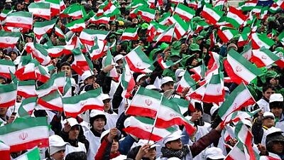 Iranians celebrate the anniversary of the Islamic Revolution in Mashhad, Iran, in 2014. Credit: Wikipedia.