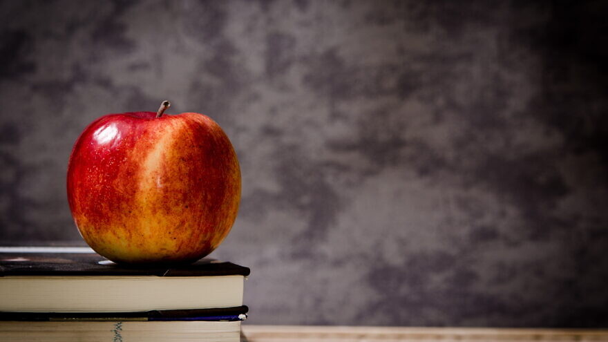 A teacher's desk with an apple. Credit: PXfuel.com