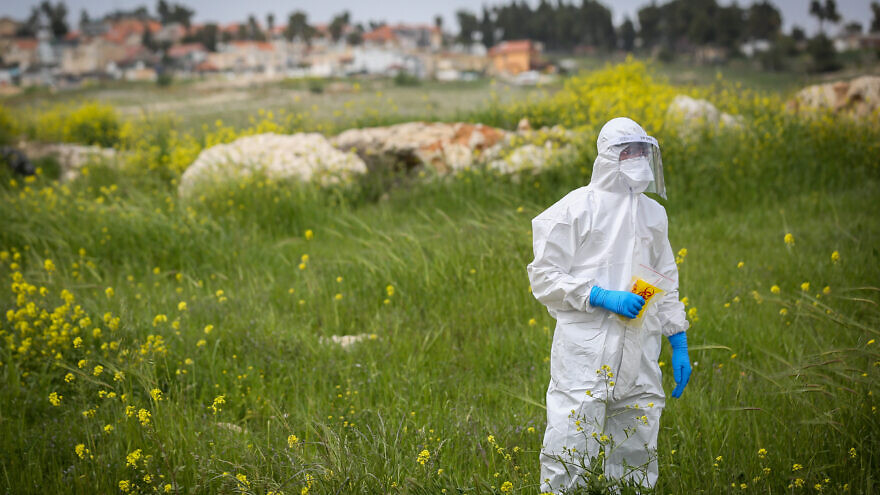 A Magen David Adom worker wearing protective clothing as a preventive measure against the coronavirus arrives to test a patient with symptoms of COVID-19 in the northern Israeli city of Tzfat, March 31, 2020. Photo by David Cohen/Flash90.