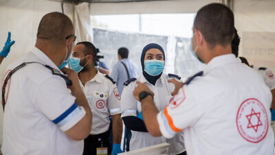 Magen David Adom medical workers collect samples for coronavirus testing at a drive-through testing site at the entrance to the eastern Jerusalem village of Jabel Mukaber on April 2, 2020. Photo by Yonatan Sindel/Flash90.