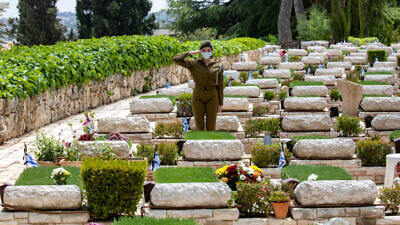An Israeli soldier salutes at the Mount Herzl Military Cemetery in Jerusalem, on the eve of Israel's Memorial Day, April 26, 2020. Photo by Olivier Fitoussi/Flash90.