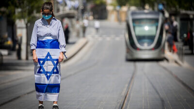 Pedestrians and drivers stand still as a siren sounds across Israel to mark Yom Hazikaron, the country's Memorial Day, which commemorates fallen Israeli soldiers and victims of terror, in Jerusalem on April 28, 2020. Photo by Yonatan Sindel/Flash90.