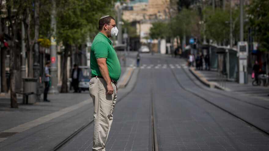 Standing in Jerusalem as a two-minute siren is sounded across Israel to mark Yom Hashaoh, Holocaust Remembrance Day, on April 21, 2020, which is followed a week later by Yom Hazikaron, Memorial Day, and Yon Ha’atzmaut, Israel’s birthday. Photo by Yonatan Sindel/Flash90.