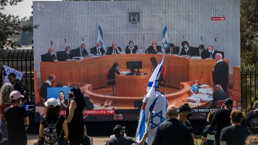 Israelis watch a Supreme Court session on petitions filed against the proposed government, outside the Knesset, April 3, 2020. Photo by Yonatan Sindel/Flash90