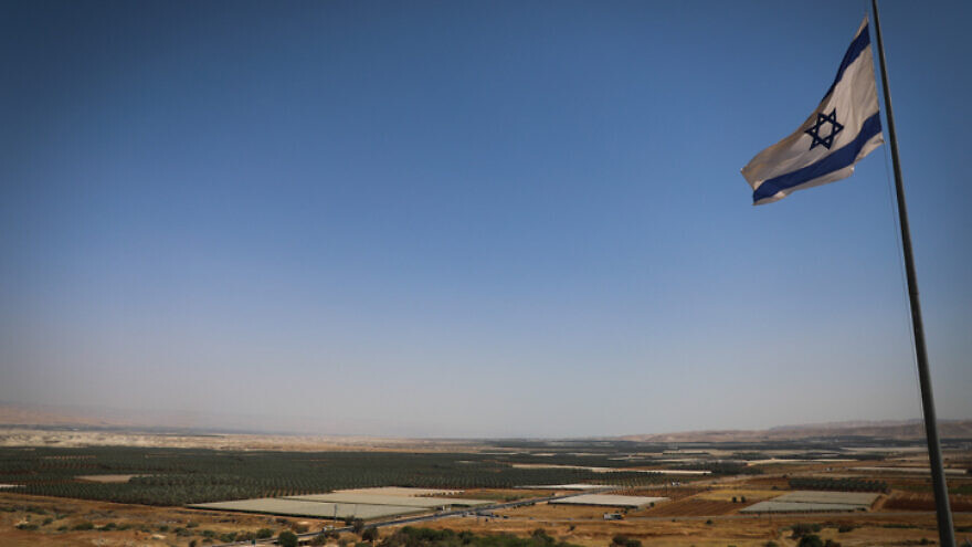 An Israeli flag with a view of the Jordan Valley, on June 14, 2020. Photo by Yonatan Sindel/Flash90.