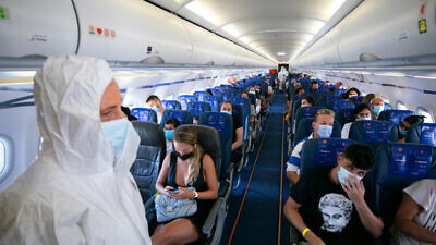 Israir Airlines flight attendants in full protective gear on a flight between Tel Aviv and Eilat on Aug. 17, 2020. Photo by Olivier Fitoussi/Flash90.