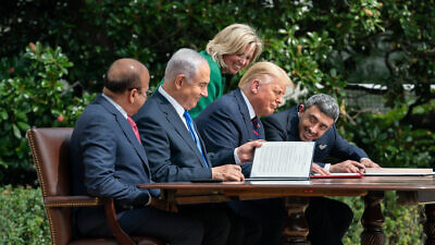 U.S. Chief of Protocol Cam Henderson assists U.S. President Donald Trump, Minister of Foreign Affairs of Bahrain Abdullatif bin Rashid Al Zayani, Israeli Prime Minister Benjamin Netanyahu and Minister of Foreign Affairs for the United Arab Emirates Abdullah bin Zayed Al Nahyan with the documents during the signing of the Abraham Accords on the South Lawn of the White House, Sept. 15, 2020. Credit: Andrea Hanks/White House.