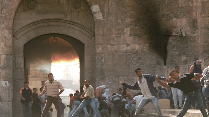 Israeli Arab citizens throw rocks at Israeli police near the Lion Gate in Jerusalem's Old City on Oct. 06, 2000, at the start of the Second Intifada. Photo by Nati Shohat/Flash90.