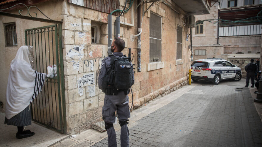 An Israeli police officer outside of a synagogue in Jerusalem as the government imposes coronavirus restrictions, April 5, 2020. Photo by Yonatan Sindel/Flash90.