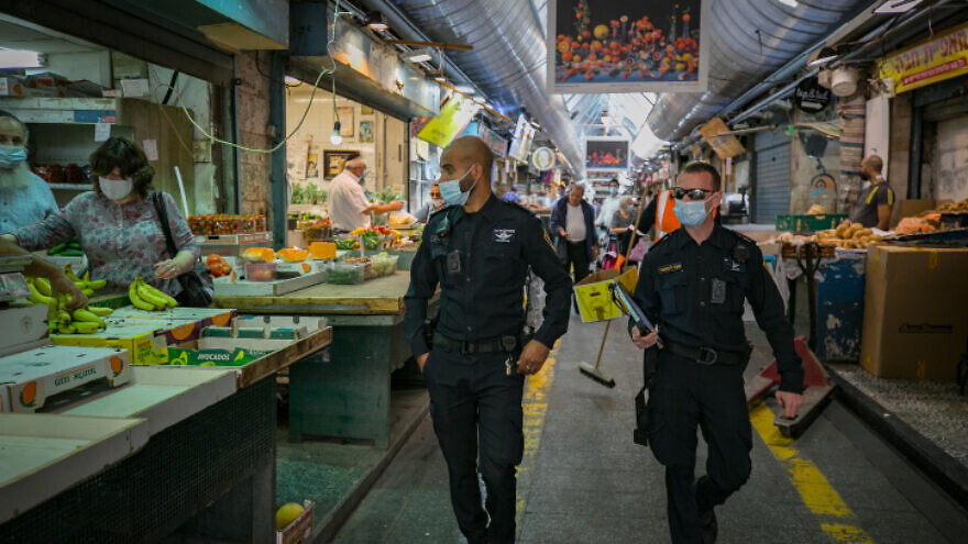 Israeli police officers on patrol at Machane Yehuda outdoor market in Jerusalem during a nationwide lockdown to prevent the spread of the coronavirus, Oct. 13, 2020. Photo by Olivier Fitoussi/Flash90.