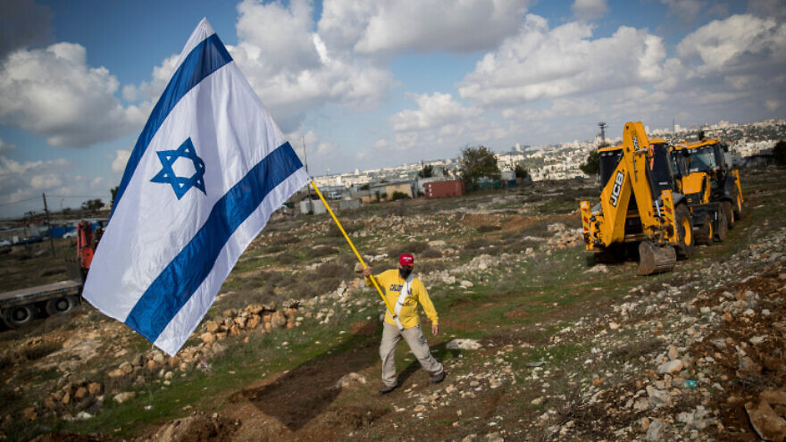 A man walks with an Israeli flag in the neighborhood of Givat HaMatos in Jerusalem on Nov. 16, 2020. Photo by Yonatan Sindel/Flash90.