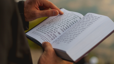 Reciting commemorative prayers from the Hebrew Bible. Credit: kaddishinitiative.com.