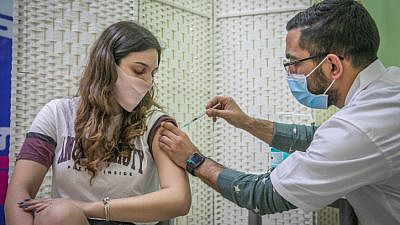A young woman gets vaccinated at Clalit COVID-19 vaccination center in Rehovot on Jan. 4, 2021. Photo by Yossi Aloni/Flash90.