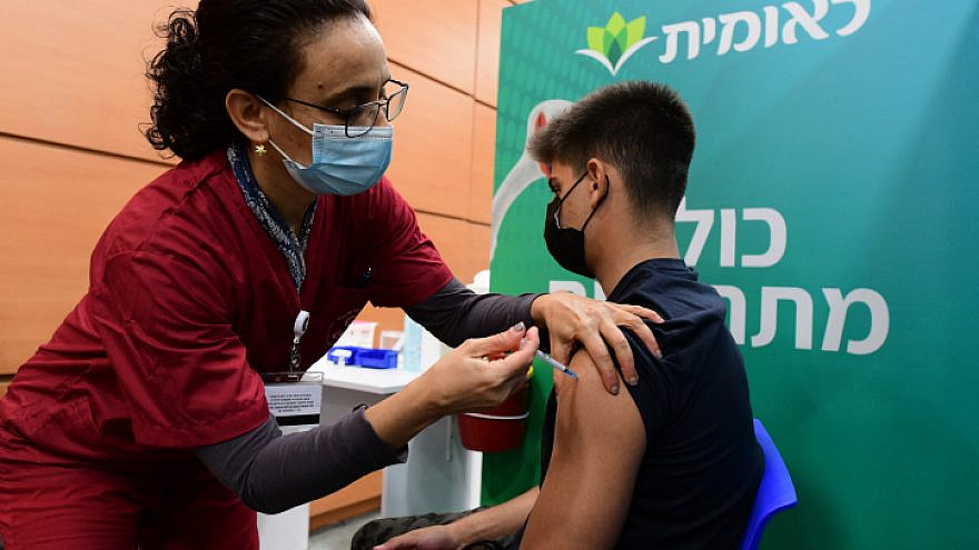An Israeli student receives a COVID-19 vaccine in Tel Aviv after Israel approved vaccination of 11th- and 12th-graders, Jan. 23, 2021. Photo by Avshalom Sassoni/Flash90.