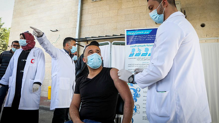Palestinian health workers in the West Bank city of Bethlehem are vaccinated against COVID-19 after a delivery of vaccine doses arrives from Israel on Feb. 3, 2021. Photo by Wisam Hashlamoun/Flash90.