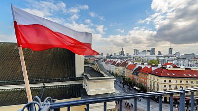 The Polish flag with Warsaw in the background. Credit: Velishchuk Yevhen/Shutterstock.
