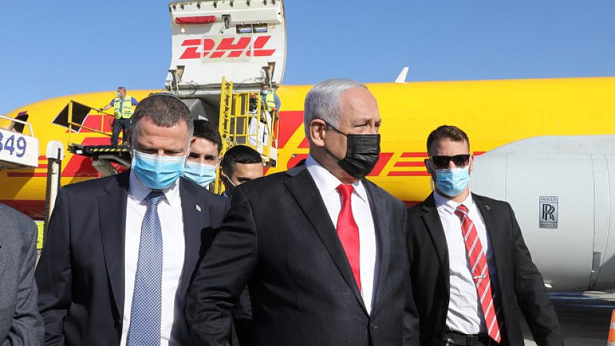 Israeli Prime Minister Benjamin Netanyahu and Health Minister Yuli Edelstein attend the arrival at Ben-Gurion International Airport of the DHL cargo jet bearing the first batch of Pfizer-BioNTech COVID-19 vaccines, Dec. 9  2020. Photo by Marc Israel Sellem/POOL.
