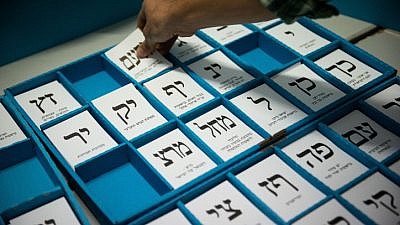 Ballot slips for competing parties are seen at a polling station in Jerusalem as Israelis vote in the March 23, 2021, election. Credit: Yonatan Sindel/Flash90.