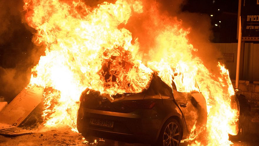A car burns in Acre during Arab rioting in the city, May 12, 2021. Photo by Roni Ofer/Flash90.