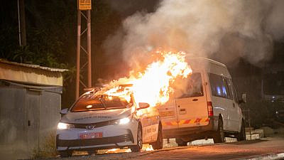 An Israel Police patrol car burns in Lod, where synagogues and cars were torched amid riots by the city's Arab residents, May 12, 2021. Photo by Yossi Aloni/Flash90.