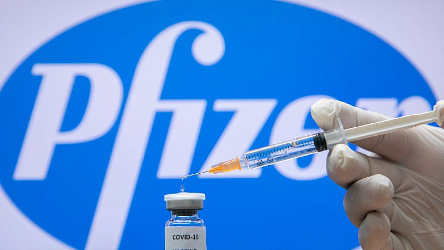 A photo illustration of a syringe and and a bottle reading "Covid-19 Vaccine" next to the Pfizer company logo in Jerusalem on December 10, 2020. Photo by Olivier Fitoussi/Flash90.