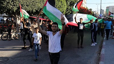 Palestinians hold signs and flags during an anti-Israel protest in Rafah, in the Gaza Strip, June 15, 2021. Photo by Abed Rahim Khatib/Flash90