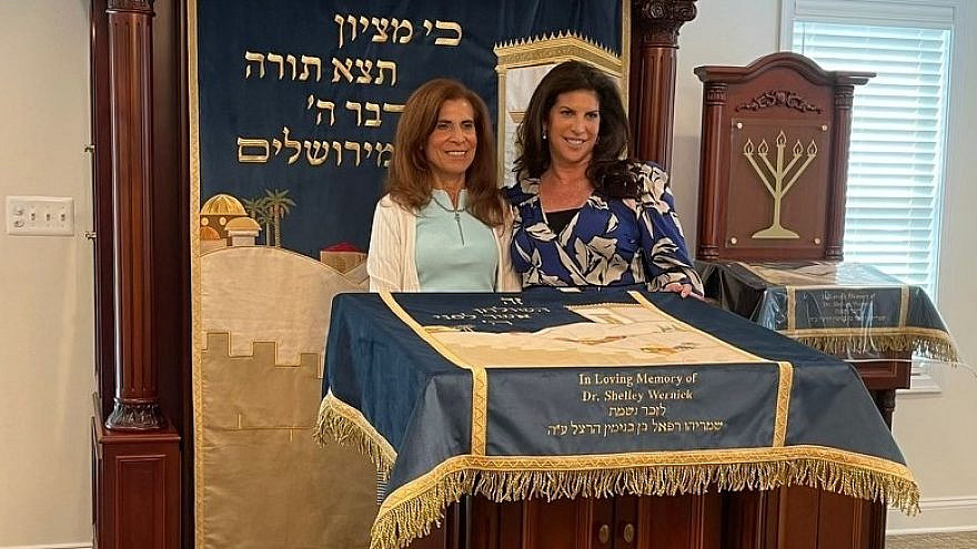 Political fundraiser Lisa Spies (right) posing for photos with her mother, Susan Wernick (left), at a private dedication event on Father's Day in front of the donations—an ark, bimah, amud—the cantor's lectern—and parochet, that she and her husband, attorney Charlie Spies made in honor of her late father, Dr. Shelley Wernick, to the Chabad Lubavitch of Alexandria-Arlington. Photo by Daniel Perez.
