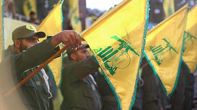 Hezbollah flags during a funeral salute. Credit: Crop Media/Shutterstock.
